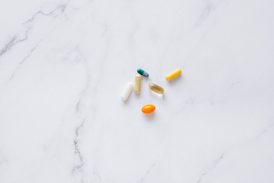A variety of differently shaped and colored pills spread out, illustrating why pill shapes can vary between medications