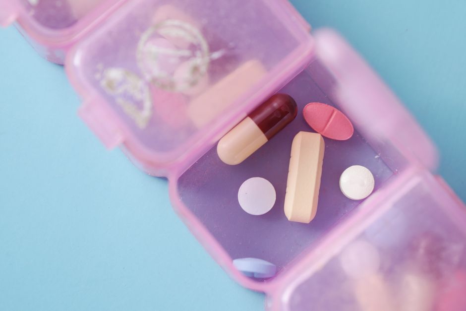 Adderall pills next to a daily planner representing medication management and routine