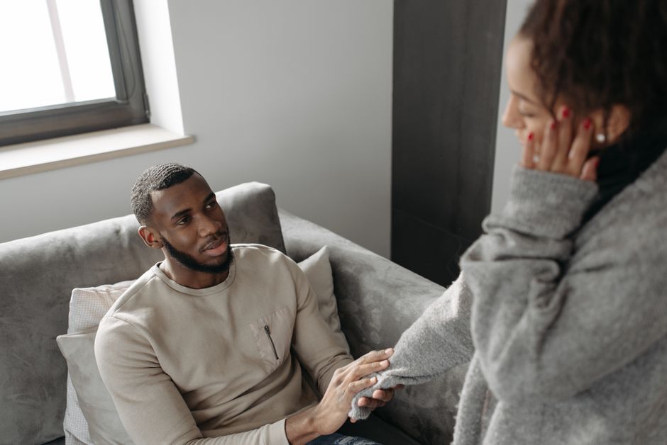 Couple sitting apart on a bed, representing intimacy challenges linked to oxycodone and sexual health