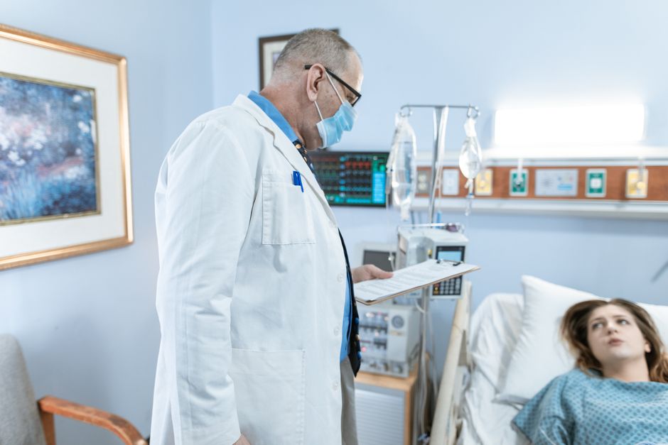 Doctor showing a patient a numeric pain scale chart before discussing oxycodone treatment