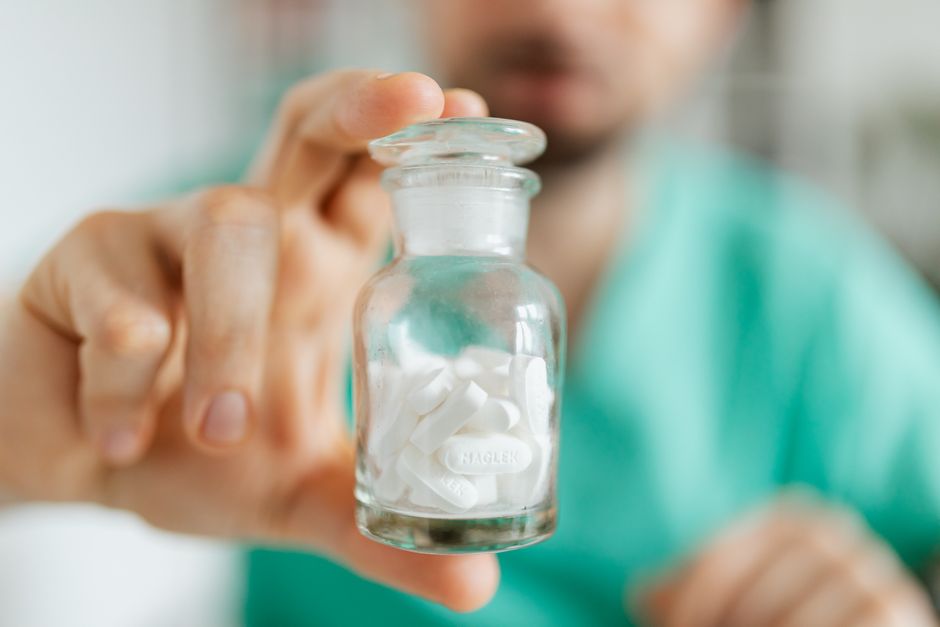 Man looking distressed while holding an oxycodone pill bottle, representing the link between oxycodone and mental health