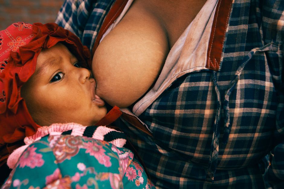 Nursing mother holding her baby while considering medication safety during breastfeeding