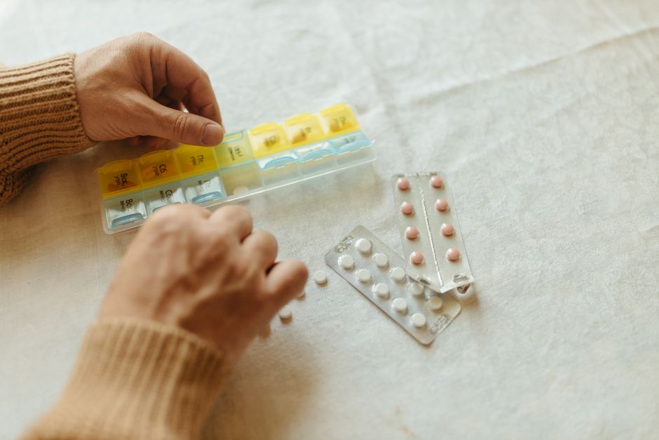 Older adult holding a prescription bottle of oxycodone pills at home