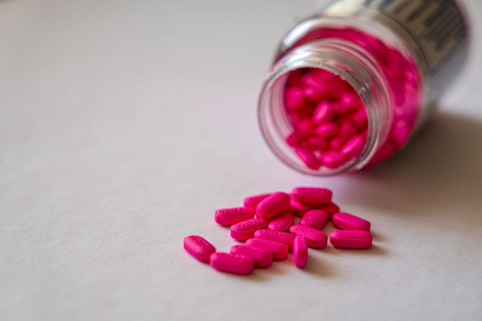 Oxycodone pill bottle next to a glass of water and light snack on a table