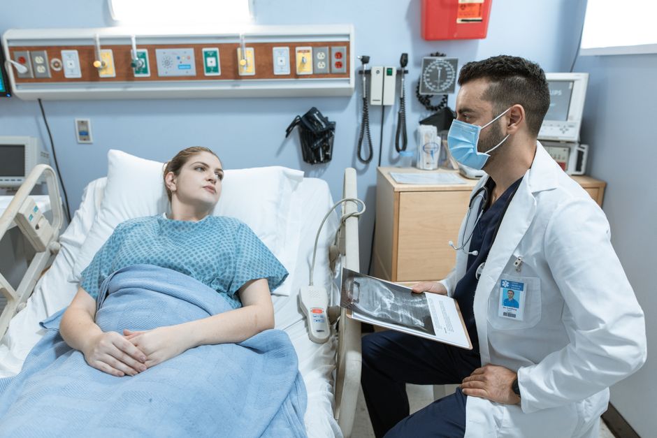 Patient recovering after hip replacement surgery while discussing oxycodone pain management with a nurse