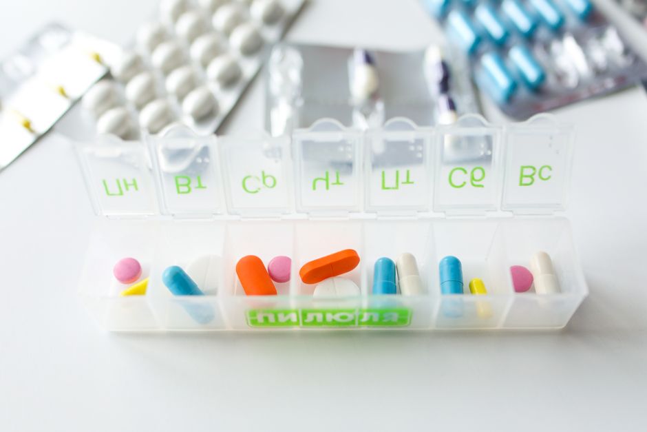Patient reviewing an oxycodone medication checklist with pill bottle and organizer on a table