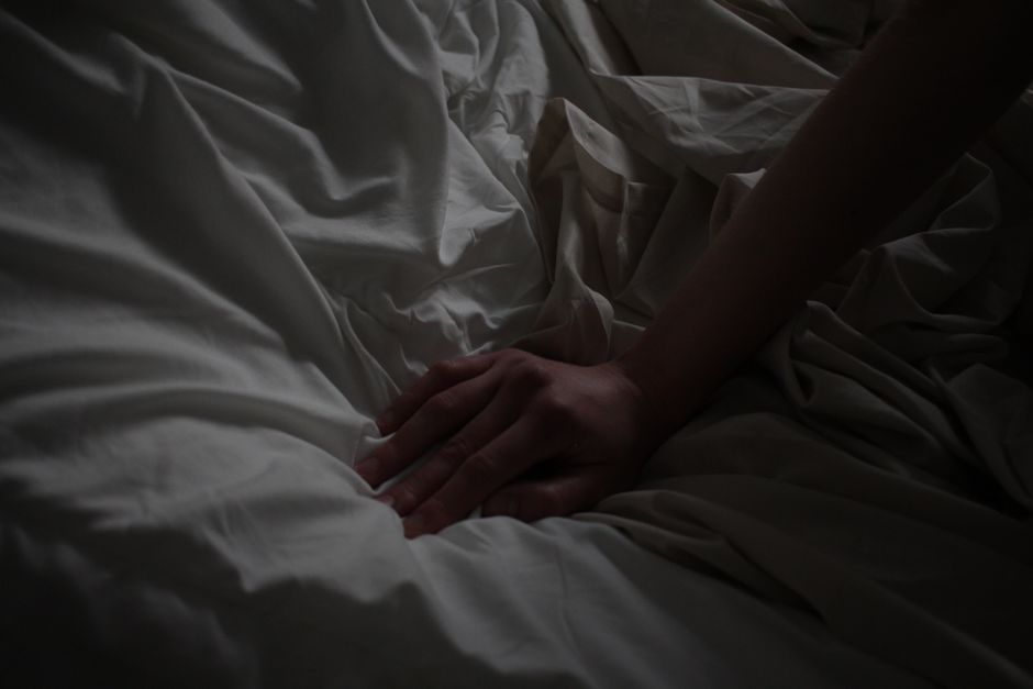 Person lying awake in bed at night struggling with sleep problems related to oxycodone use