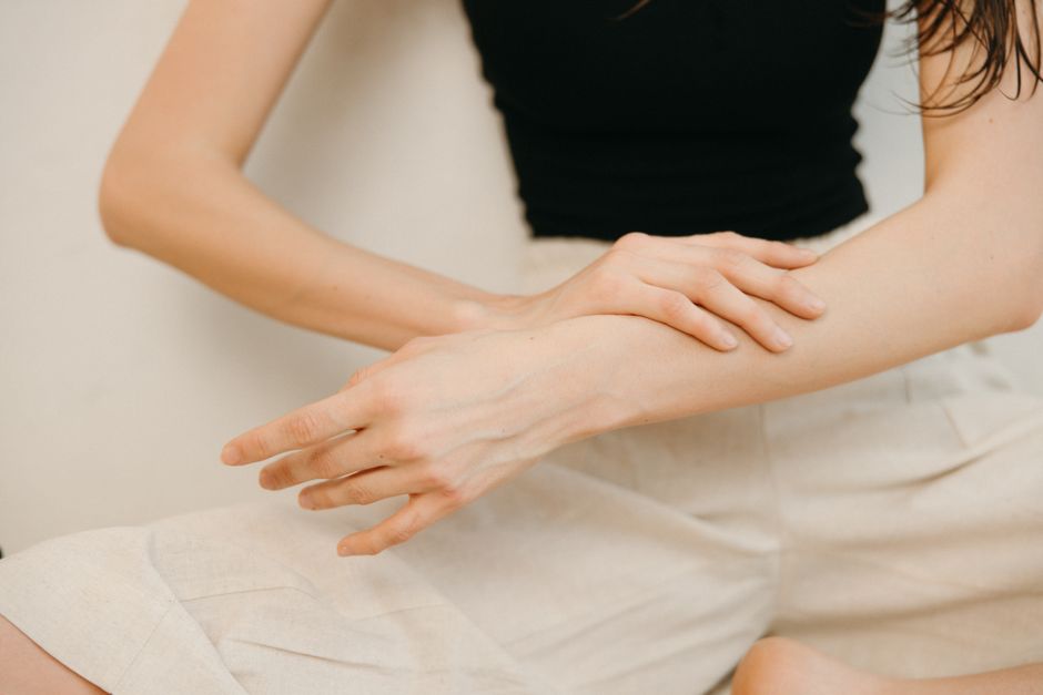 Person scratching their arm due to itching without a visible rash, a possible oxycodone side effect