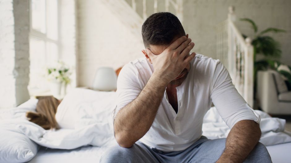 Person sitting on the edge of a bed looking tired, representing the Adderall withdrawal timeline