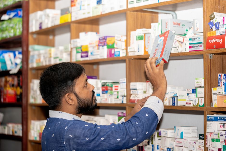 Pharmacist checking empty medication shelf due to a pharmacy stock shortage