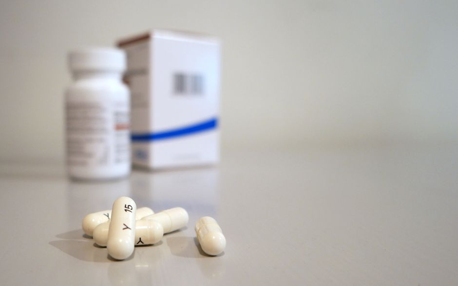 Pharmacist handing over an oxycodone prescription at a pharmacy counter