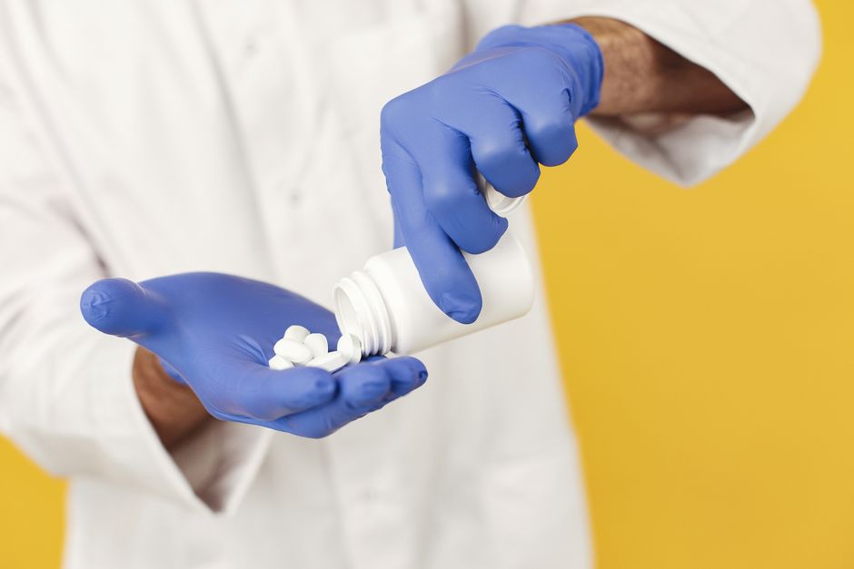 Pharmacist reviewing an oxycodone prescription discount coupon at the pharmacy counter