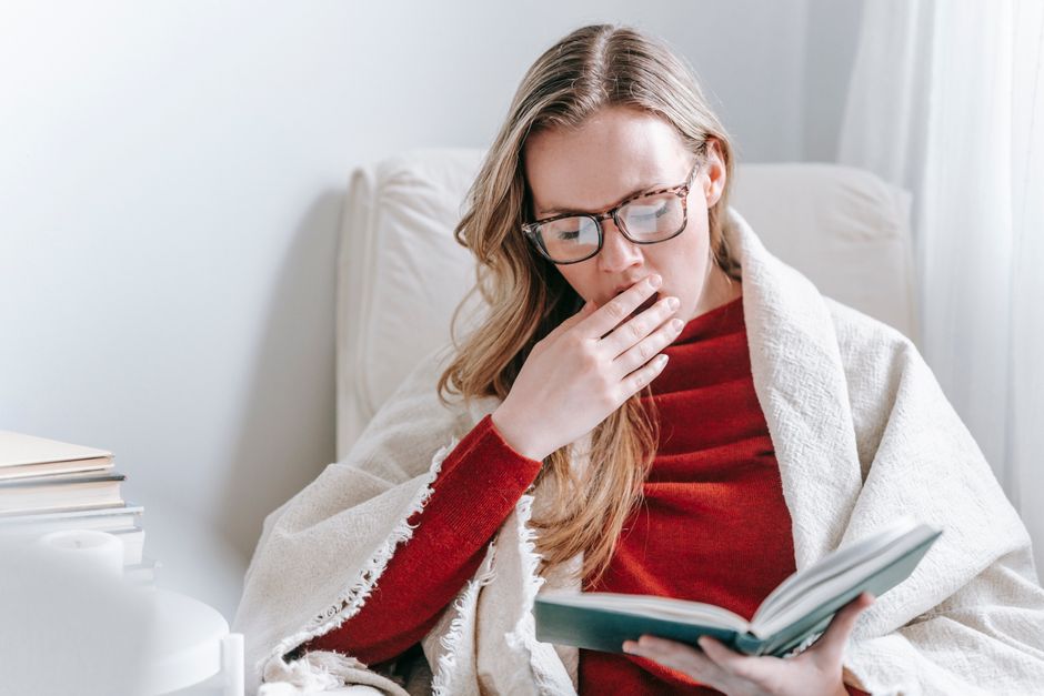 Tired woman rubbing her eyes at her desk from fatigue