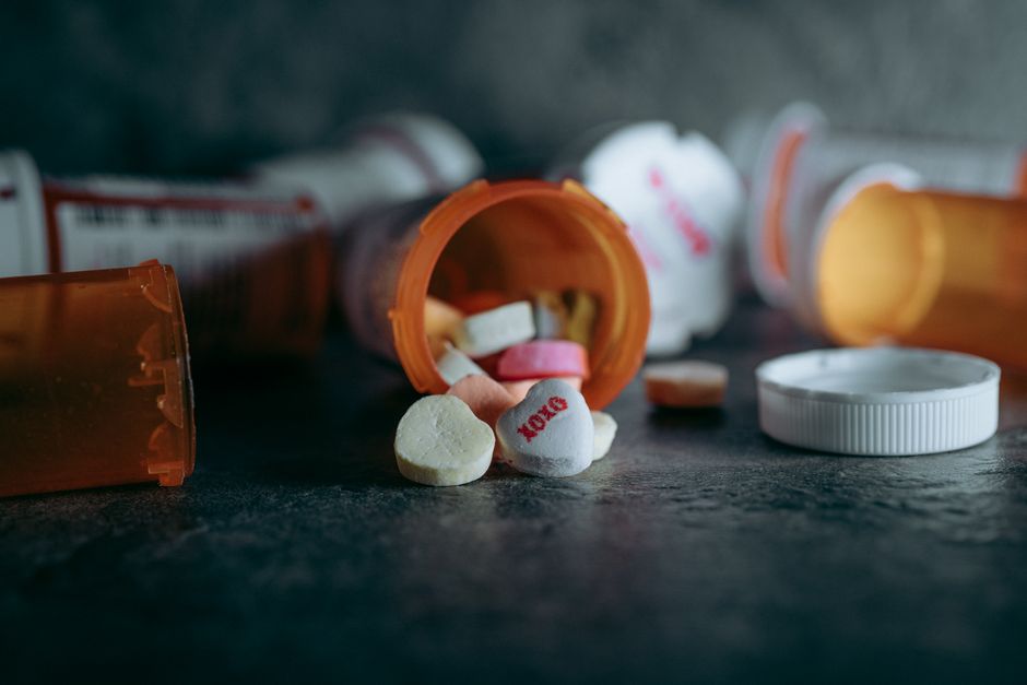 Bottle of hydrocodone pills next to a warning label symbolizing medication safety precautions