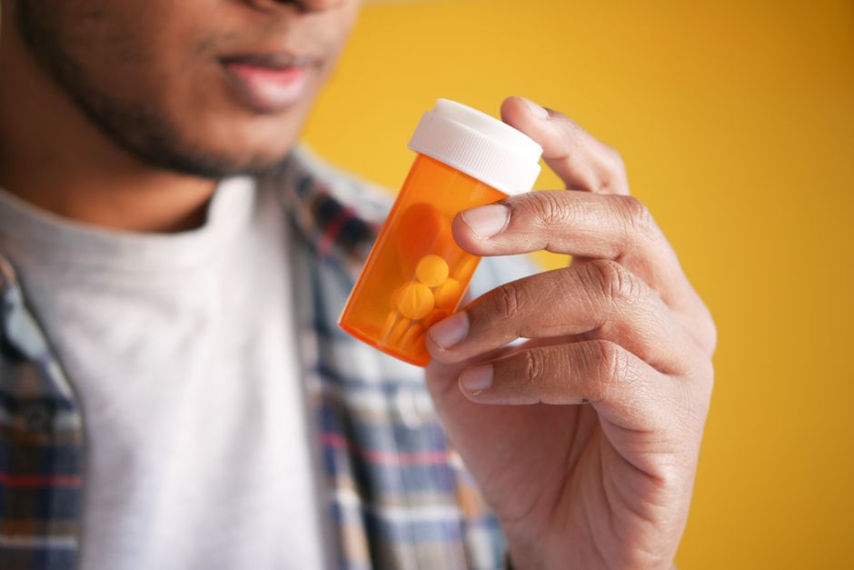 Pharmacist reviewing a Schedule II controlled substance prescription at the pharmacy counter