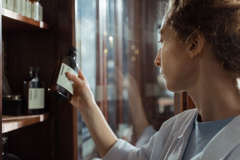 Pharmacist verifying a DEA-regulated oxycodone prescription at the pharmacy counter