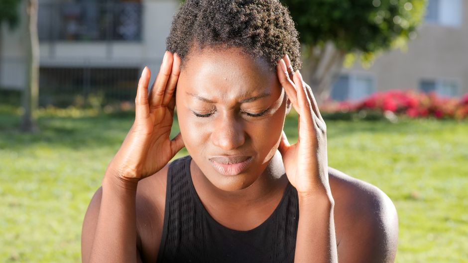 Woman holding her head due to a headache possibly caused by hydrocodone medication